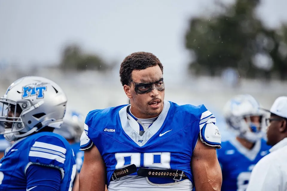 Alex Williams in a blue football jersey with eye black on the sideline